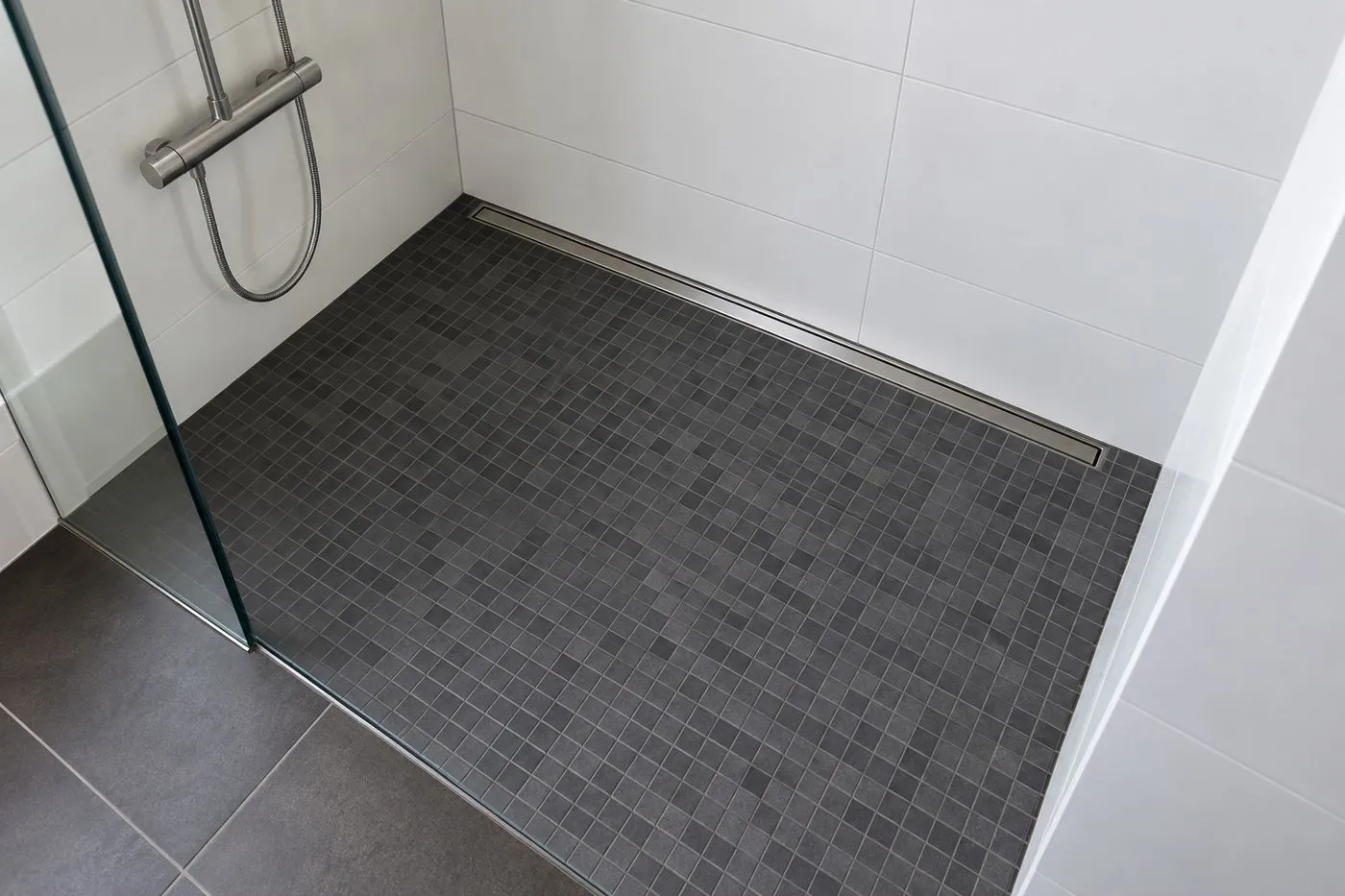 Douche à l'italienne avec un sol en mosaïque gris anthracite en pente vers un caniveau